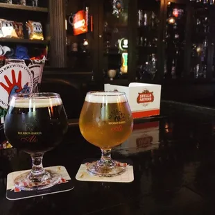 two glasses of beer on a bar