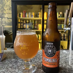 a glass of beer next to a bottle