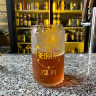 a glass of beer on a bar