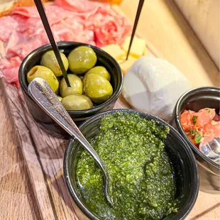 a wooden cutting board with olives and bread