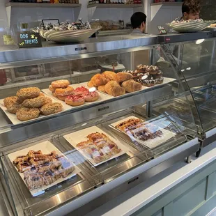 a variety of pastries displayed in a display case