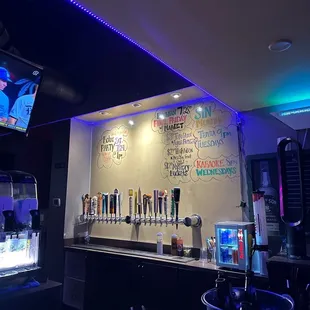 a bar with neon lights and a menu on the wall