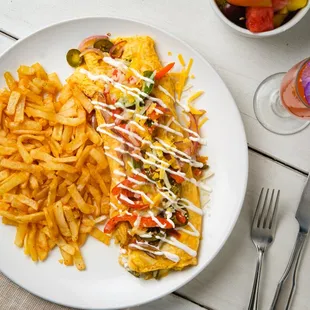 Spanish omelette is made with green bell peppers, tomatoes, onions, jalapeños, Monterey Jack Cheese, sharp cheddar, topped with sour cream.