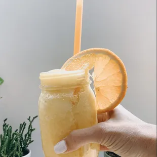 a hand holding a jar of iced coffee