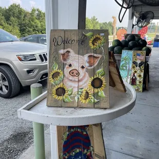 a pig and sunflowers painted on wood planks