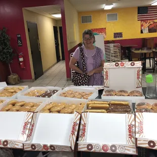 a woman standing in front of boxes of donuts