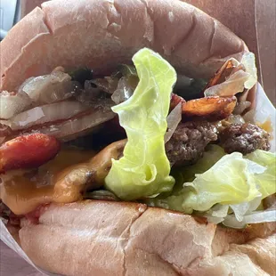a hamburger with lettuce, tomatoes, and onions