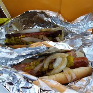 two hot dogs wrapped in tin foil