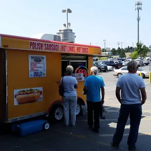 a group of people standing in front of a food truck