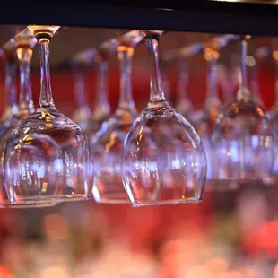 wine glasses hanging from a bar