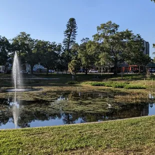 Restaurant is located across from a small park with a fountain.