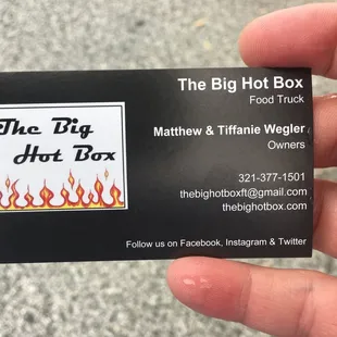 a hand holding a business card