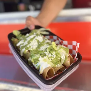 Chicken and cheese taquito with green salsa