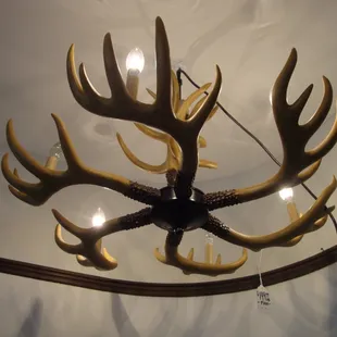 A large hanging lamp with faux deer antlers.
