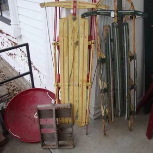 A few vintage snow sleds next to the front door.