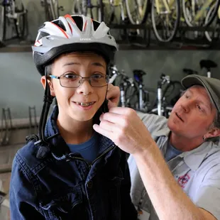 Rick fitting a helmet on a young rider.