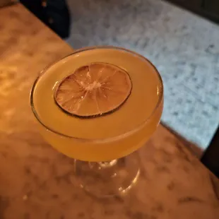 a cocktail with a slice of lemon on the rim