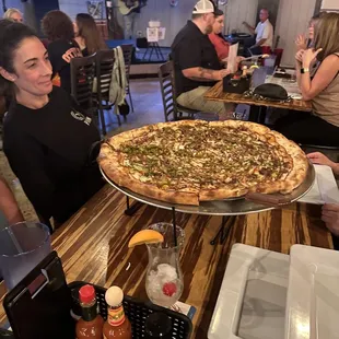 a woman holding a pizza