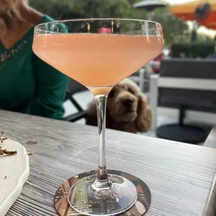 a woman sitting at a table with a drink