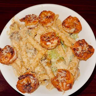 a plate of pasta with shrimp and broccoli