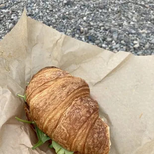 Breakfast sandwich on a croissant with roasted tomatoes, spinach, feta and Mama Lil&apos;s aioli. Best breakfast sandwich ever!