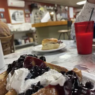 a plate of french toast with berries and whipped cream