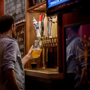 a man pouring a beer at a bar