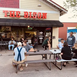 a group of people sitting at picnic tables