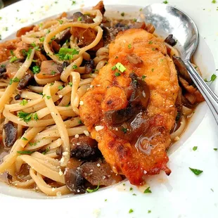 a plate of pasta with chicken and mushrooms