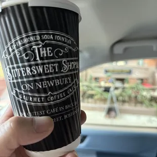 a hand holding a coffee cup