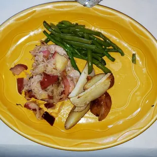Pork chop with baked apples and sauerkraut, green beans and roasted potatoes.