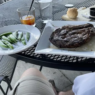 a steak on a plate with a side of green beans