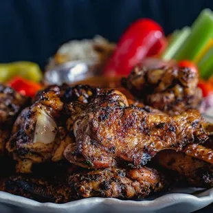 a plate of chicken wings and vegetables