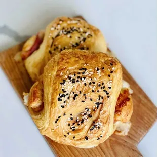 a wooden cutting board with two pastries on it