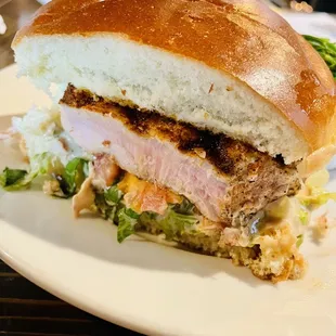 a sandwich with meat, lettuce, and coleslaw