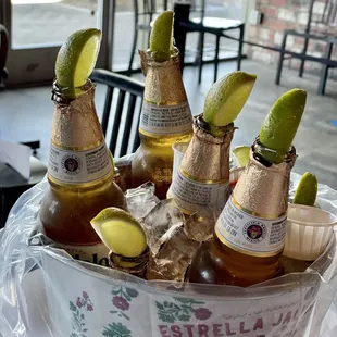 ix bottles of beer with lime wedges