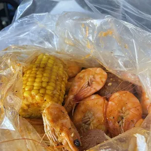 Mild lemon pepper shrimps with a cob of corn and potatoes
