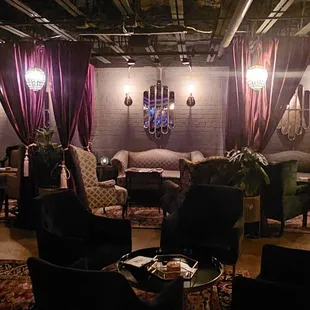 a living room with couches, chairs, and a chandelier