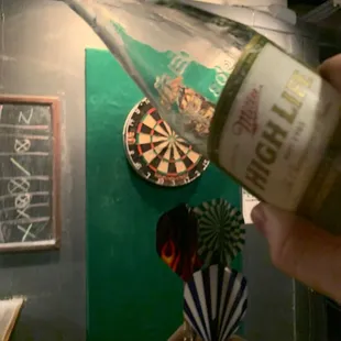 a hand holding a bottle of beer