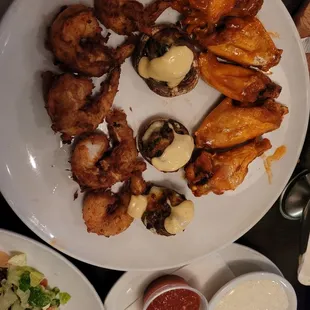 a plate of chicken wings and salad