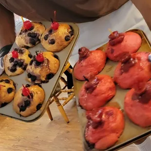 a person holding a tray of pastries