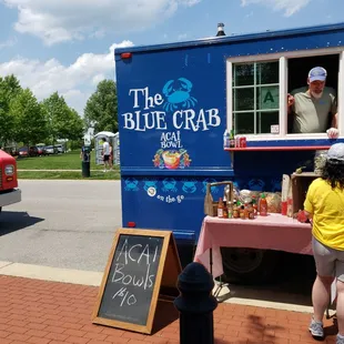 a man and a woman standing in front of a food truck