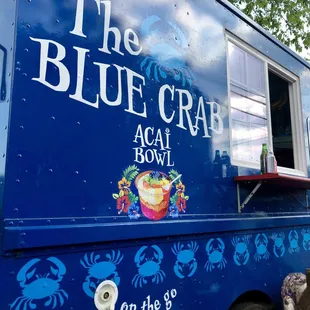 a blue food truck with blue crabs painted on it