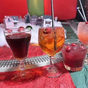 three glasses of different drinks on a table