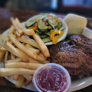 a plate of food with french fries and a salad