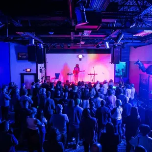 a crowd of people standing in front of a stage