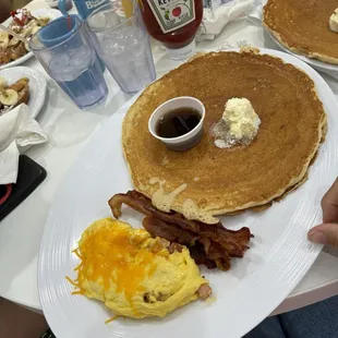 Pancake, bacon, scrambled eggs with cheese.