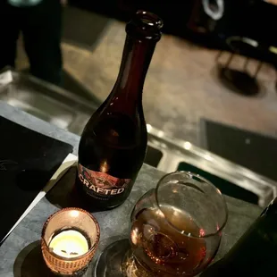 a bottle of beer and a candle