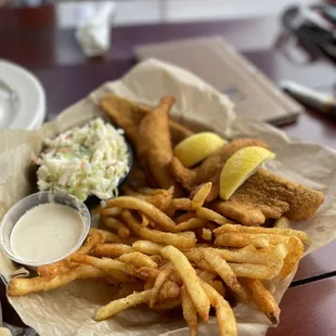 a basket of fish and chips with coleslaw and coleslaw slaw
