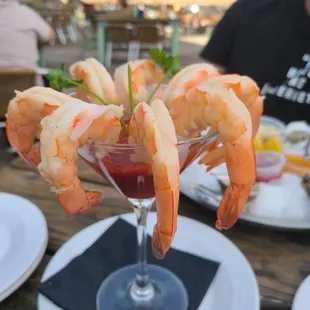 a glass of shrimp cocktail on a table